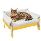 Cat lying on a fluffy white pet bed with wooden legs 